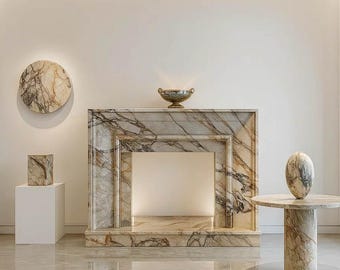 May include: A marble fireplace with a decorative bowl, a round marble table, and a marble sculpture. The fireplace and table have a grey and brown veined pattern. A marble cube sits on a white plinth.