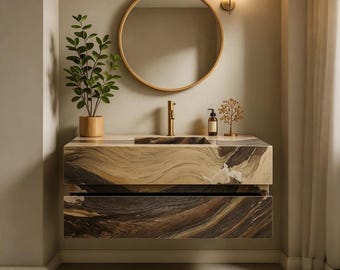 May include: A contemporary bathroom vanity featuring a natural stone countertop and two drawers. The countertop incorporates a built-in sink and a gold tap. A circular gold mirror is mounted above the vanity. A small plant and decorative items are on the surface.