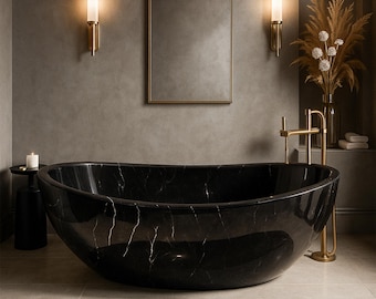 May include: A luxurious bathroom featuring a black marble bathtub with white veining. The room includes a gold-framed mirror, sconces, and a gold faucet. A small black side table with a candle and a vase of dried flowers complete the elegant design.