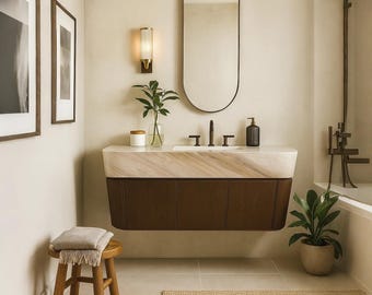 May include: A contemporary bathroom interior with a floating vanity unit. The vanity has a marble top and dark brown cabinets. An oval mirror is mounted above the sink, and a wall light is visible. A small wooden stool with a folded blanket is in the foreground.