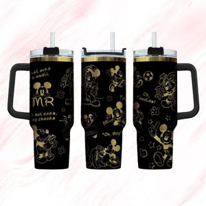 Puede incluir: Tres vasos de acero inoxidable negro y dorado con diseños de Mickey Mouse. Los vasos tienen asas y tapas negras con detalles dorados. Los vasos presentan diferentes diseños de Mickey Mouse, incluyendo Mickey Mouse con un bate de béisbol, Mickey Mouse con un balón de fútbol y Mickey Mouse con una guitarra. Los vasos también presentan el texto "Oh, Boy!" y "Toodles!"