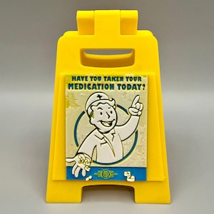 May include: A bright yellow, plastic sign with the text "HAVE YOU TAKEN YOUR MEDICATION TODAY?" and a cartoon image of a doctor. The doctor is pointing upwards and holding pills. The sign is a-frame style.