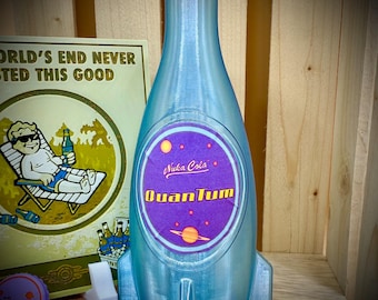 May include: A light blue Nuka Cola Quantum bottle with a purple cap and label. The label features the words "Nuka Cola Quantum" and a planet design. The bottle is rocket-shaped with fins. A sign behind the bottle reads "World's End Never Tasted This Good".