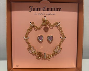 May include: A gold-tone bracelet and earrings set with pink accents. The bracelet features a charm with the word "Juicy" and the earrings are heart-shaped. The set comes in a pink and gold box with the Juicy Couture logo and the text "Los Angeles, California".