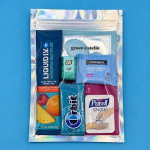 Puede incluir: Una bolsa transparente y resellable que contiene artículos de tocador y refrigerios de viaje. Incluye un sobre de mezcla hidratante Liquid I.V., caramelos Tic Tac, una toallita desmaquillante Neutrogena, chicle Orbit y desinfectante de manos Purell.