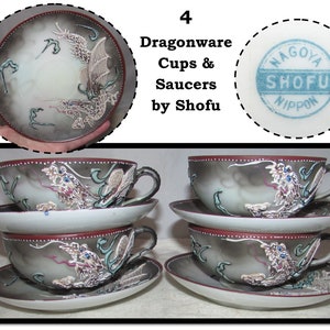 May include: Set of four vintage Japanese Dragonware teacups and saucers. The cups and saucers feature a gray and white background with a silver dragon design. The saucers have a red rim with white dots. The cups have a red rim with white dots and a silver dragon design. The bottom of the saucers has a blue stamp that reads "Nagoya Shofu Nippon".