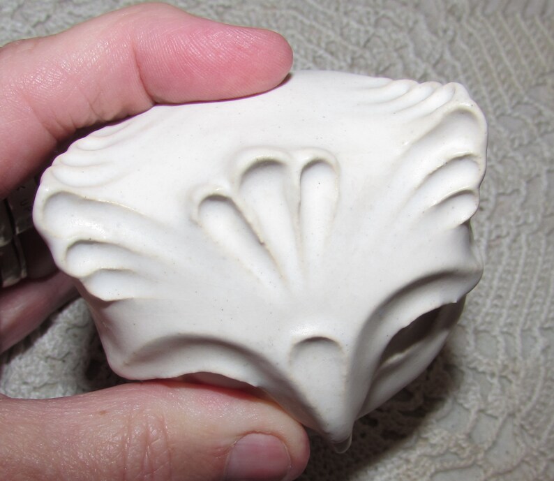 May include: White ceramic owl figurine with detailed textured feathers and a round shape.