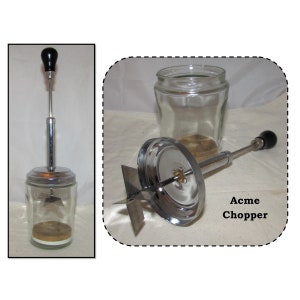 May include: A vintage Acme Chopper food processor with a glass jar and a chrome blade. The chopper has a black handle and a chrome base.