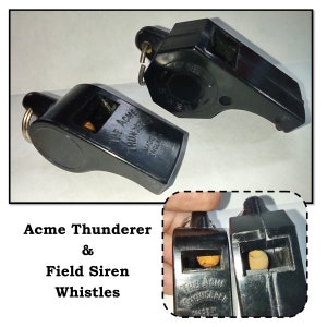 May include: Two black plastic whistles, one labeled "The Acme Thunderer Made in England" and the other labeled "The Acme Thunderer Made in England".