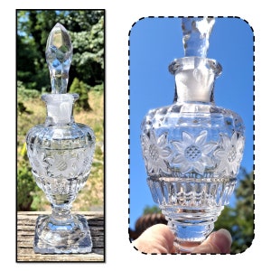 May include: A clear glass bottle with a stopper and a floral design. The bottle is on a wooden surface.