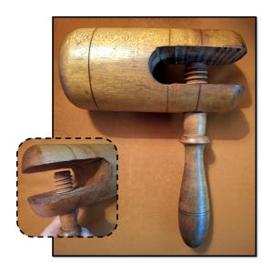 May include: A vintage wooden clamp with a screw mechanism. The clamp is made of light brown wood and features a handle and a large opening for holding objects. The screw is visible in the center, allowing for adjustable pressure. The clamp is likely used for woodworking or crafts.
