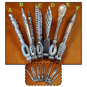 May include: Six silver nutcrackers with intricate designs. The nutcrackers are arranged in a row, with the handles facing up. The nutcrackers are all different shapes and sizes, but they all have a similar design. The nutcrackers are made of metal and have a polished finish.