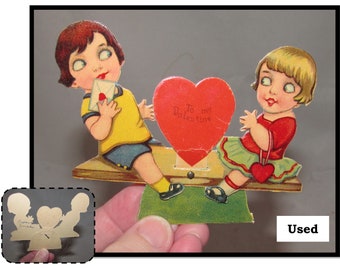 Tarjeta de felicitación mecánica antigua troquelada independiente para el Día de San Valentín, niña y niño en balancín, *USADA