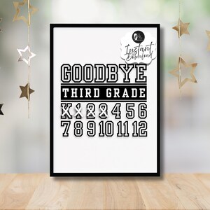 Könnte beinhalten: Ein gerahmter Schwarz-Weiß-Druck mit den Worten "GOODBYE THIRD GRADE" in fetten Blockbuchstaben. Darunter die Zahlen 1 bis 12. Der Druck wird auf einer Holzoberfläche mit sternförmigen Dekorationen im Hintergrund präsentiert.