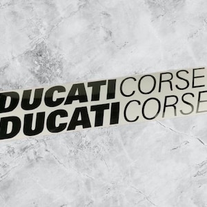 以下が含まれることがあります： 「DUCATI CORSE」という文字が2回繰り返された白黒のステッカーです。