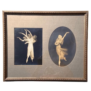 May include: Framed vintage artwork featuring two ballet dancer images. One image shows three dancers in white dresses, the other shows a single dancer in a flowing gown. The frame is gold with a silver matting.
