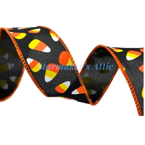 May include: Black ribbon with an orange and white candy corn pattern. The ribbon has an orange edge.