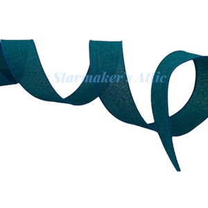 May include: Teal blue burlap ribbon with a subtle texture. The ribbon is woven and has a slightly frayed edge.