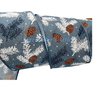 May include: Blue and white wired ribbon with a pine cone and leaf pattern. The ribbon has a wired edge and is 2.5 inches wide.