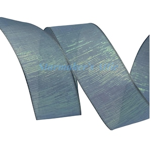 May include: A length of iridescent ribbon in shades of blue and green. The ribbon has a textured appearance and a subtle sheen. The edges are neatly finished, and the ribbon is curled, suggesting it is for decorative purposes.