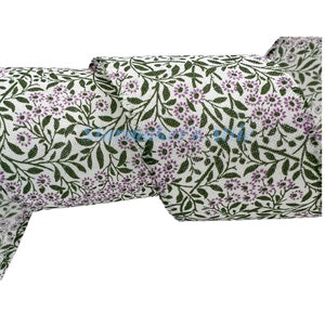 May include: White burlap ribbon with a floral pattern in shades of green and purple. The ribbon features a repeating design of small flowers and leaves.