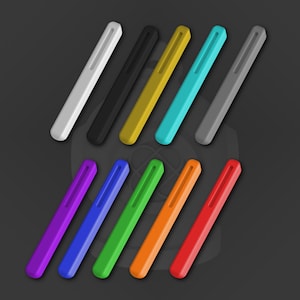 Könnte beinhalten: Ein Set mit 12 bunten, schlanken, rechteckigen Hüllen. Die Hüllen bestehen aus glattem, hartem Kunststoff und haben eine leicht abgerundete Kante. Die Farben umfassen Schwarz, Weiß, Grau, Gold, Türkis, Lila, Blau, Grün, Orange und Rot.