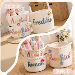 May include: Off-white cotton rope storage baskets featuring personalised names in colourful yarn lettering. The baskets are decorated with small fabric flowers, a lion, or a car. Some baskets contain plush toys and bottles of baby lotion.