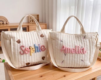 Borsa fasciatoio trapuntata personalizzata con nome in filato, orsetto e motivi floreali, ideale come regalo per baby shower o per neonati.
