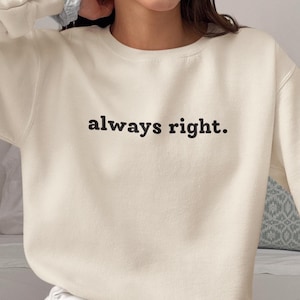 May include: A white crew neck sweatshirt with the text "always right." printed in black.
