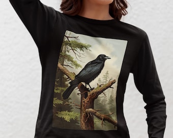 Può includere: Maglietta nera a maniche lunghe con un'illustrazione vintage di un corvo appollaiato su un ramo in un ambiente boschivo.