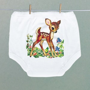 May include: White cotton underwear with a brown and white deer print. The deer is standing in a field of flowers with two blue birds.