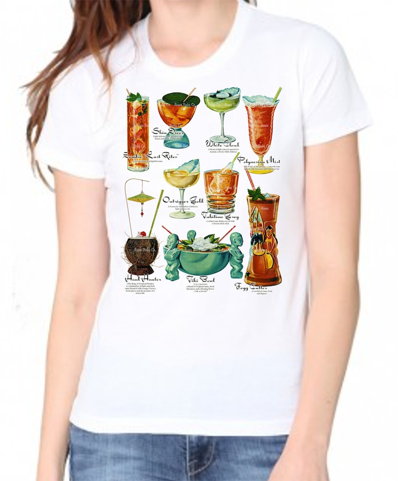 Op de afbeelding: Wit T-shirt met een kleurrijke illustratie van verschillende tropische cocktails. De namen van de cocktails staan ​​onder elke afbeelding. De cocktails omvatten: Zombie, Last Rites, Shin-Dig, White Cloud, Polynesian Mist, Outrigger Gold, Valhallian Swing, Head Hunter, Tiki Bowl en Foggy Gutter.