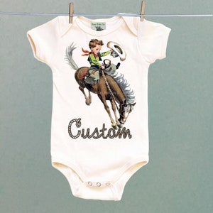 Organic Onesie™ Custom Name Retro Western One Piece Bodysuit with Buckaroo Cowboy on Horse. Cute Southwestern or Western themed baby Onesie™ natural short sleeve