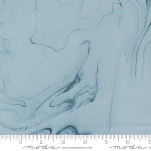 May include: A light blue fabric with a marbled pattern. The fabric has a subtle texture and a soft, flowing feel. The pattern is reminiscent of swirling clouds or water.