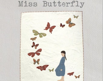 Miss Butterfly Quilt Pattern - This serene appliqué quilt features a pretty girl standing amongst a swirl of butterflies, all fluttering by