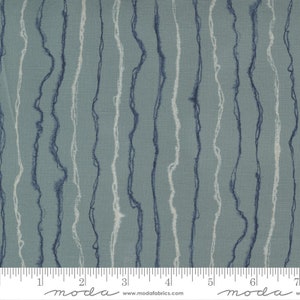 May include: A blue and white fabric with a wavy line pattern. The fabric is textured and has a subtle sheen. The fabric is shown with a ruler, with the text "moda" printed on the ruler.