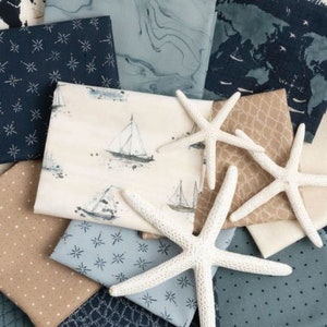 May include: A collection of fabric squares in various shades of blue and brown with white star and nautical patterns. The fabric squares are arranged in a pile with two white starfish on top.