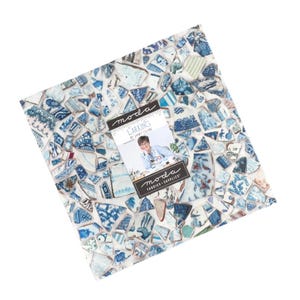 May include: A square fabric panel with a mosaic design of blue and white ceramic shards. A tag with the text "Larking" and "Moda Fabrics-Supplies" is attached. The fabric has a variety of blue patterns.