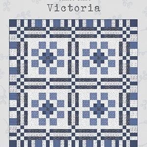 Pode incluir: Um padrão de colcha chamado "Victoria" de Janet Clare. A colcha é feita de quadrados azuis e brancos e mede 70 polegadas por 70 polegadas.