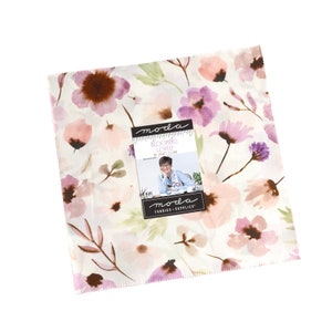 May include: A white fabric with a floral print in shades of pink, purple, and brown. The fabric features a watercolour-style design with delicate flowers and leaves. The fabric is labelled "Moda Fabrics - Supplies" and "Blooming Lovely by Janet Clare".
