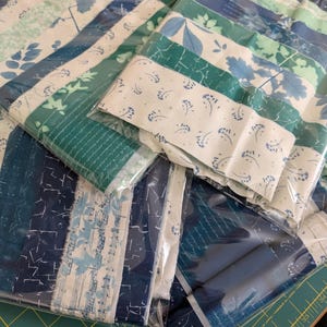 May include: A white ceramic mug with a black handle and the text "But First, Coffee" in a black, bold font. The mug is on a white surface.