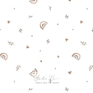 Può includere: Tessuto bianco con un motivo ripetuto di arcobaleni, cuori e ramoscelli ad acquerello nei toni del marrone. Il testo "Studio Gc FABRICS MADE FOR MAKERS" è stampato in corsivo.