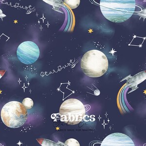 Può includere: Tessuto blu navy con un tema spaziale ad acquerello. Il design include pianeti, razzi, arcobaleni, stelle, costellazioni e la parola "Stardust". Il tessuto presenta anche il testo "Fabrics on the Co."