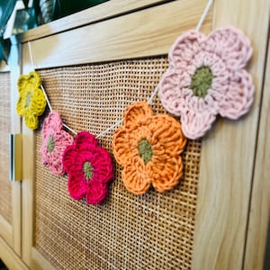 Gehaakte slinger met wilde bloemen. Kwekerijslinger. Kinderkamerdecoratie. Wanddecoratie