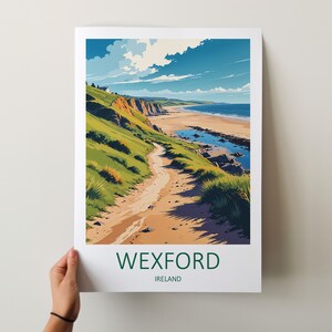 May include: A print featuring a coastal landscape with a path leading to a beach. The artwork showcases green hills, a sandy path, and a blue ocean under a partly cloudy sky. The word "WEXFORD" and "IRELAND" are printed at the bottom.