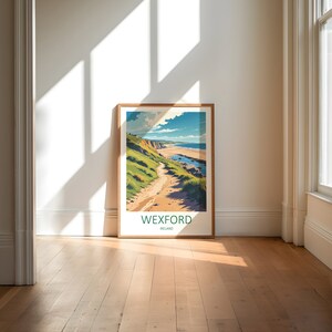 May include: A framed art print featuring a coastal landscape with a path leading to the beach. The artwork showcases a vibrant scene with green hills, a sandy path, and a blue ocean under a bright sky. The text "WEXFORD IRELAND" is at the bottom.