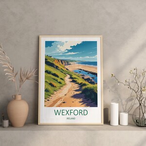 May include: Framed art print featuring a coastal landscape with a path leading to a beach. The artwork showcases a vibrant scene with green hills, a sandy beach, and a blue sky with clouds. The text "WEXFORD IRELAND" is at the bottom.