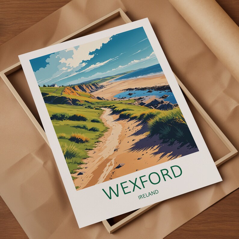 May include: A framed art print featuring a coastal landscape with a sandy path leading to a beach. The artwork showcases a vibrant scene with green hills, blue water, and a bright sky. The word "WEXFORD" is printed in green at the bottom.