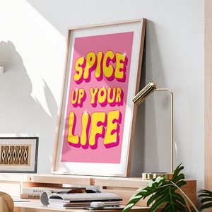 May include: A pink and yellow motivational poster with the text "Spice Up Your Life" in a retro font.