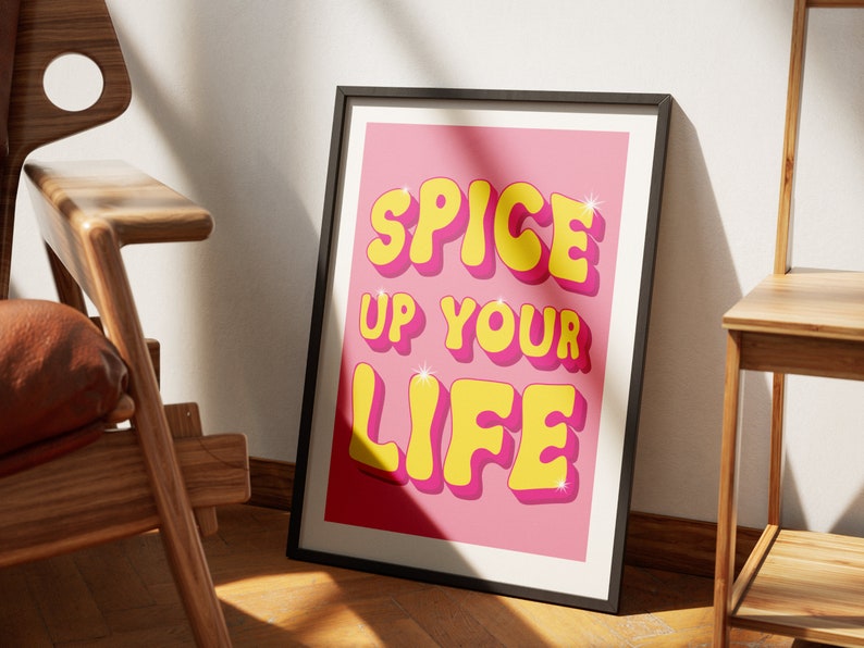 May include: A pink poster with the text "Spice Up Your Life" in yellow, 3D letters with a glittery effect.
